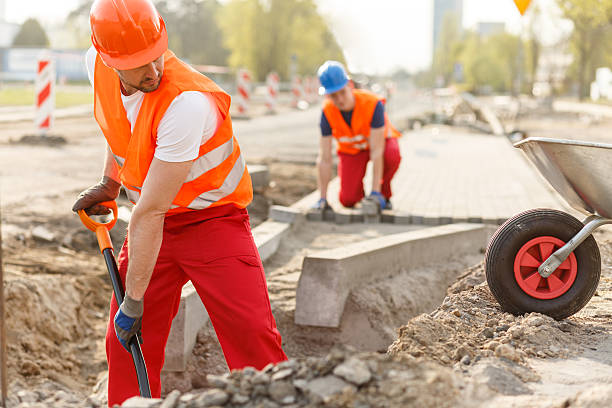 Two hard working builders in uniforms putting pavement